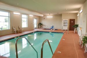 Jefferson的住宿－Cobblestone Hotel and Suites - Jefferson，游泳池位于酒店客房内,配有桌椅