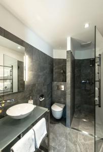 a bathroom with a sink and a toilet and a shower at Roosevelt Stadthaus in Vienna +122 photos