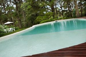 a swimming pool with two chairs and a table at Hosteria Mi Casa en la Sierra in Tandil
