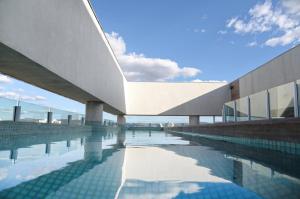 a swimming pool in front of a building at Dubai Suites in Montes Claros