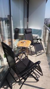 3 chaises et une table sur un balcon dans l'établissement Centro apartamentai - Vingio apartamentai, à Vilnius