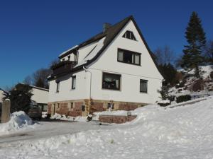 Una gran casa blanca con nieve en el suelo en Ferienhaus Johanna en Schmalkalden