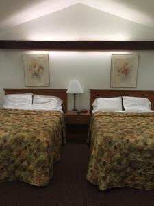 a hotel room with two beds and a lamp at North King Motel in Northampton