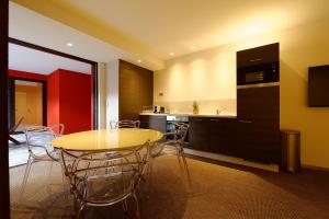 - une cuisine et une salle à manger avec une table et des chaises dans l'établissement The One Apartments, à Ribeauvillé