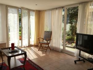 een woonkamer met een televisie, een stoel en een tafel bij Casa Fiorella in Locarno