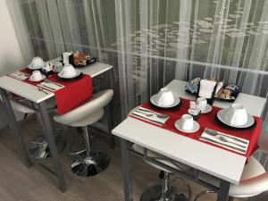 ein Esszimmer mit 2 Tischen und einem roten und weißen Tisch in der Unterkunft 85Centro in Potenza