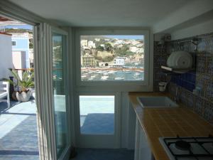 uma cozinha com duas janelas e vista para um porto em la mansarda sul mare em Ponza