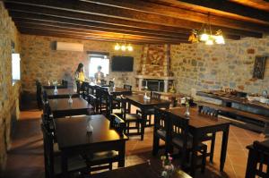 a restaurant with wooden tables and chairs and a fireplace at Pirgoi Edem in Pyrgos Dirou