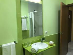 
a bathroom with a sink and a mirror at Hotel Lince in Aznalcázar

