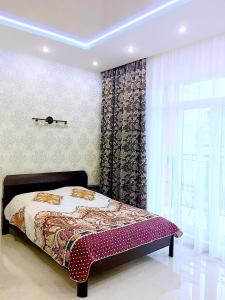 a bedroom with a bed and a window at Apartments Malina in Svetlogorsk
