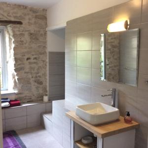 un baño con lavabo y espejo en Maison Ancienne Minervois, en La Caunette 65 fotos más