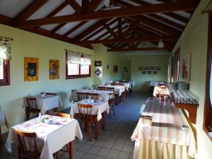 a restaurant with tables and chairs with white tablecloths at Pousada Barratur in Florianópolis