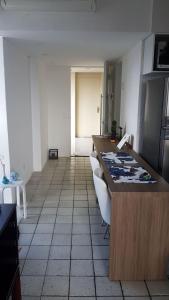 a kitchen with a counter and some chairs in it at Aconchegante Flat na Orla in Recife +11 photos