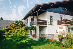 een wit huis met een zwart dak bij Apartments Poklukar in Bled