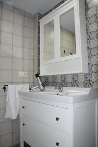een badkamer met een witte wastafel en een spiegel bij Teatro Rojas in Toledo