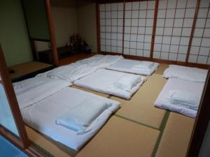 a group of white beds in a room at Setonejuan in Takamatsu
