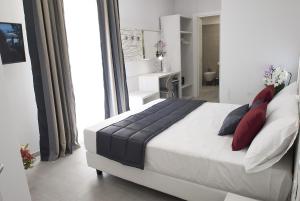 a bedroom with a large white bed with red pillows at Merulana Holidays in Rome