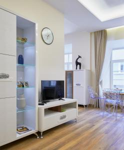 a living room with a tv and a white cabinet at Town Hall Square Apartments in Vilnius