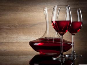 two glasses of red wine sitting on a table at Riverside Guest Lodge in Oudtshoorn