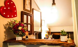 um quarto com uma mesa com flores e um espelho em Pousada Santarina em Florianópolis