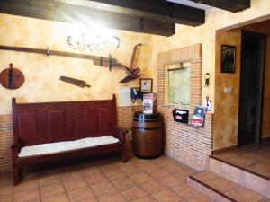 una habitación con un banco y un barril en la pared en Casa Rural Julian en Medinaceli