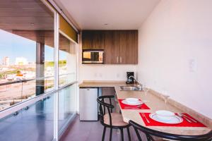 a kitchen with a table and chairs and a kitchen with a view at Millenium Plaza & Suites in San Luis Potosí