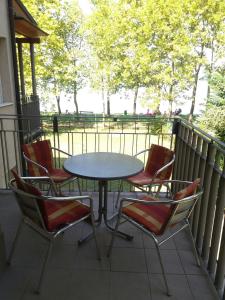un tavolo e sedie su un balcone con tavolo e sedie di Anita Apartment a Balatonboglár
