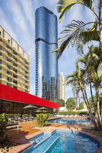 a swimming pool in a city with a tall building at Royal On The Park in Brisbane