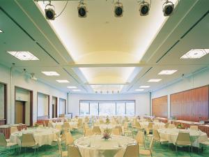 屋久島にある屋久島いわさきホテルの白いテーブルと椅子が備わる宴会場