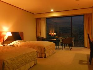 屋久島にある屋久島いわさきホテルのベッド2台とバルコニー付きのホテルの部屋 +24枚の写真