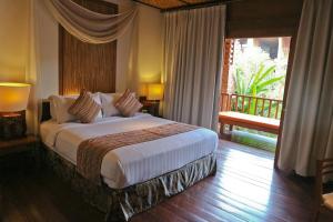 Schlafzimmer mit einem großen Bett und einem Balkon in der Unterkunft Grand Mega Resort & Spa in Cepu