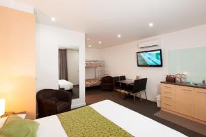 ein Hotelzimmer mit einem Bett, einer Küche und einem Schreibtisch in der Unterkunft Mansfield Motel in Mansfield