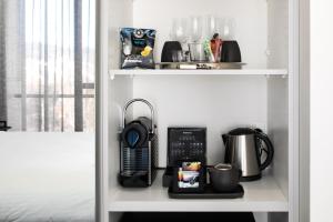 a white shelf with a coffee maker and a coffee pot at Knightsbridge Canberra in Canberra