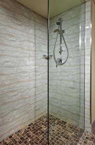 
a shower stall with a glass door and a shower curtain at Stamford Grand Adelaide in Adelaide
