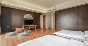 a bedroom with two beds and a television in it at Bo Heng B&B in Magong