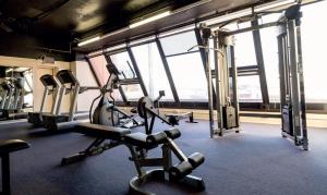 a gym with several tread machines in a room with windows at Stamford Grand Adelaide in Adelaide