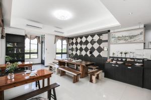a dining room with wooden tables and benches at Bo Heng B&B in Magong