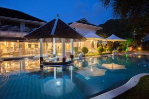 a swimming pool in front of a hotel at night at Access Resort & Villas in Karon Beach
