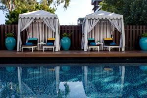 twee tuinhuisjes met stoelen naast een zwembad bij Wave Hotel Pattaya in Pattaya
