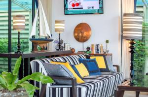 a living room with a striped couch and lamps at Wave Hotel Pattaya in Pattaya Central