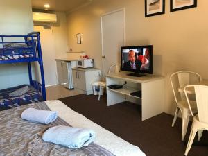 a bedroom with a bed and a television at Bayview Motel Rosebud/Rye in Rosebud
