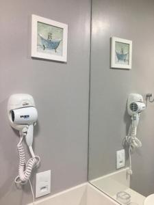 a bathroom with two hair dryers and a mirror at Loft Paris in Niterói