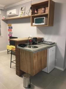 una pequeña cocina con fregadero y microondas en Loft Paris, en Niterói