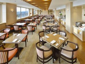 una sala da pranzo con tavoli e sedie di Grand Hotel Hamamatsu a Hamamatsu