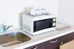 a microwave oven sitting on top of a kitchen counter at Condominium Hotel Monpa in Chatan
