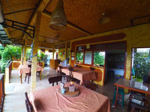 a restaurant with tables and chairs and windows and a table at Pondok Batur Indah Homestay Karangasem in Tirtagangga +29 photos