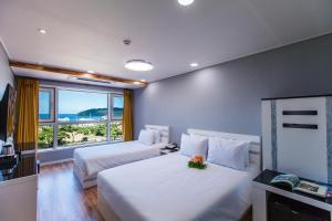 Postel nebo postele na pokoji v ubytování Hotel Sweet Castle Jeju Hamdeok