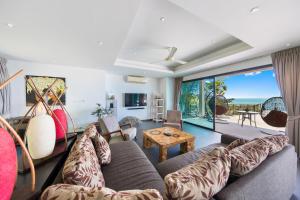 una sala de estar con un sofá y una mesa en Ban Nai Fan - Private Pool Villa, en Choeng Mon Beach