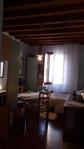 ein Zimmer mit einem Tisch und einem Bett mit einem Fenster in der Unterkunft Macri in Montagnana