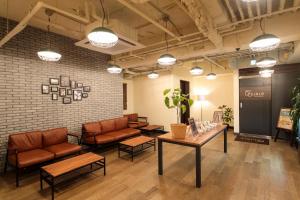 a waiting room with couches and tables and a brick wall at Hotel Double Funabashi in Funabashi